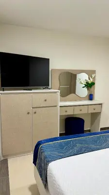 a bedroom with a bed and a desk with a television at Hotel Boutique Paralela Real. in Manizales
