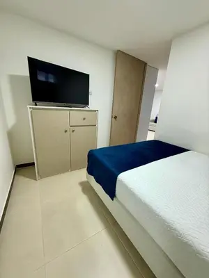 a bedroom with a bed and a flat screen tv at Hotel Boutique Paralela Real. in Manizales