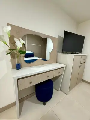 a desk with a vase of flowers and a mirror at Hotel Boutique Paralela Real. in Manizales