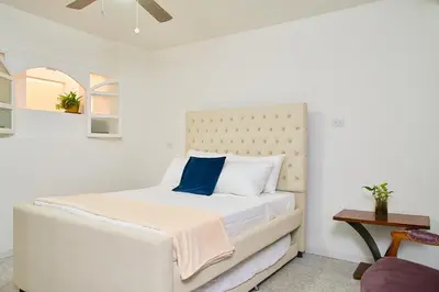 a bedroom with a white bed with a blue pillow at Hotel Boutique Fiorentina Medellín in Medellín