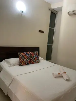 a bedroom with a bed with a towel on it at Hotel Tierra Santa Santa Fe de Antioquia in Santa Fe de Antioquia
