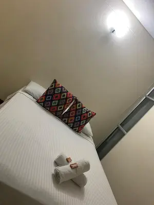 a bedroom with a bed with two towels on it at Hotel Tierra Santa Santa Fe de Antioquia in Santa Fe de Antioquia