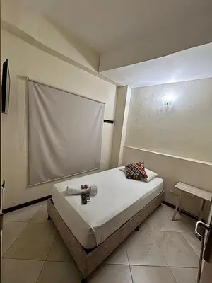 a small bedroom with a bed and a screen at Hotel Tierra Santa Santa Fe de Antioquia in Santa Fe de Antioquia