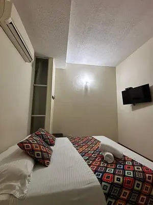 a hotel room with a bed with a television on the wall at Hotel Tierra Santa Santa Fe de Antioquia in Santa Fe de Antioquia
