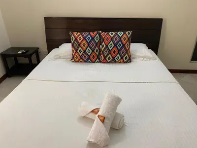 a towel sitting on a bed with a pillow at Hotel Tierra Santa Santa Fe de Antioquia in Santa Fe de Antioquia
