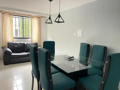 a dining room with a glass table and green chairs at no Reservar in Bello