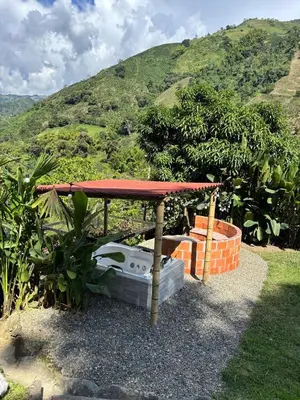 a table with a red roof on top of a garden at Apartamento campestre para pareja en Manizales in Manizales