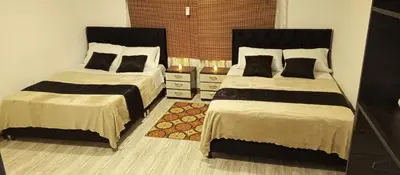 a bedroom with two beds and a rug at Hotel Palo Grande in Manizales