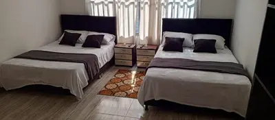 a bedroom with two beds and a window at Hotel Palo Grande in Manizales