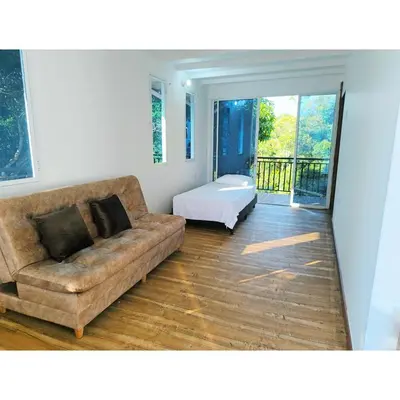 a living room with a couch and a bed at Posada Campestre en Doradal in Puerto Triunfo