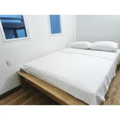 a white bed with two pillows on top of it at Posada Campestre en Doradal in Puerto Triunfo