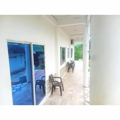 a porch of a house with chairs on it at Posada Campestre en Doradal in Puerto Triunfo
