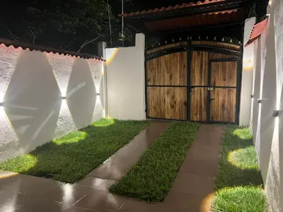 a garden with a wooden gate and grass at Loft Vacacional in Mariquita