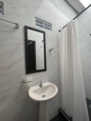 a white bathroom with a sink and a mirror at Loft Vacacional in Mariquita