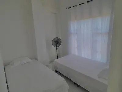 a white room with two beds and a fan at Loft Vacacional in Mariquita