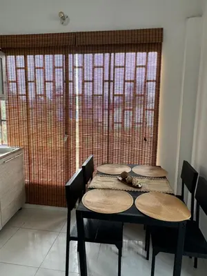 a table with four chairs in a kitchen with a window at Apartamento Vacacional Campestre in Mariquita