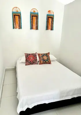 a white bed with three windows in a room at Apartamento Vacacional Campestre in Mariquita