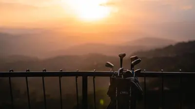 a group of golf clubs on a fence with the sunset in the background at Finca Hotel Los Alpes in Manizales