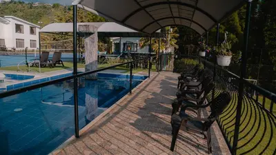 a row of benches next to a swimming pool at Finca Hotel Los Alpes in Manizales