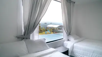 a bedroom with a window with a view of a pool at Finca Hotel Los Alpes in Manizales
