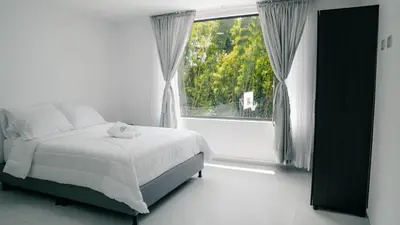 a bedroom with a bed and a large window at Finca Hotel Los Alpes in Manizales