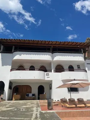 a building with a patio with chairs and an umbrella at La torrecita in Barbosa