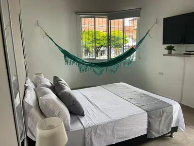 a bedroom with a bed with pillows and a window at Apartamento con vista a laureles 401 in Medellín