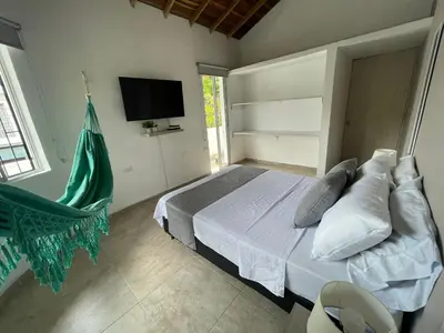 a bedroom with a bed with a television and a hammock at Apartamento con vista a laureles 401 in Medellín
