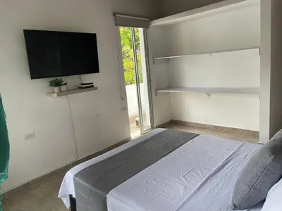 a bedroom with a bed with a tv on the wall at Apartamento con vista a laureles 401 in Medellín
