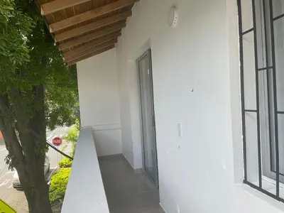 an open door in a white building with a tree at Apartamento con vista a laureles 401 in Medellín