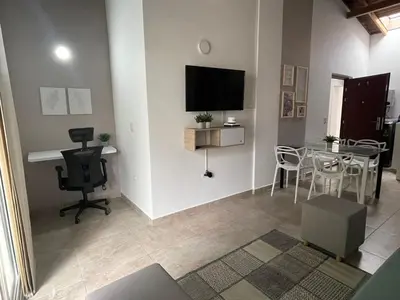 a living room with a table and a tv on a wall at Apartamento con vista a laureles 401 in Medellín