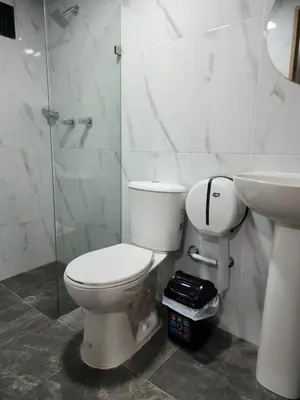 a white bathroom with a toilet and a sink at Aparta estudios Estadio la 80 in Medellín