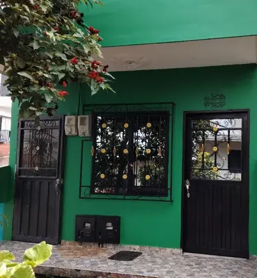 a green building with two doors and two windows at Casa en Doradal - Antioquia in Doradal