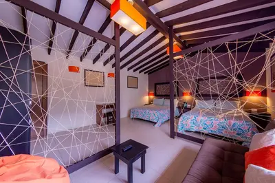 a room with two beds and a couch in a room at Ayenda Mountain Hostels Manizales in Manizales