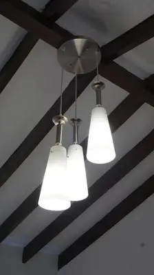 three lights hanging from a ceiling with beams at Ayenda Mountain Hostels Manizales in Manizales