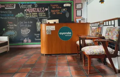 a counter in a room with chairs and a table at Ayenda Mountain Hostels Manizales in Manizales