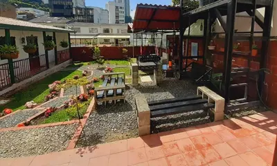 a patio with two benches and a garden at Ayenda Mountain Hostels Manizales in Manizales