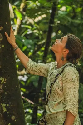 a woman is standing next to a tree at Reserva Wanaka, San Carlos in Cocorná