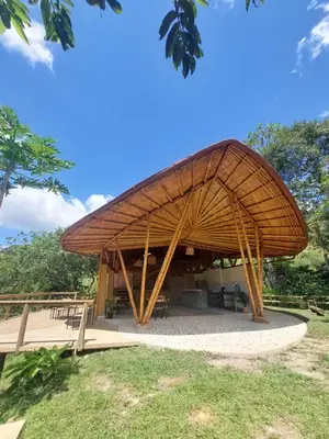 a pavilion with a bamboo roof in a park at Aracari Ecolodge in San Rafael