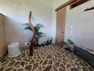 a bathroom with a palm tree mural on the wall at Aracari Ecolodge in San Rafael