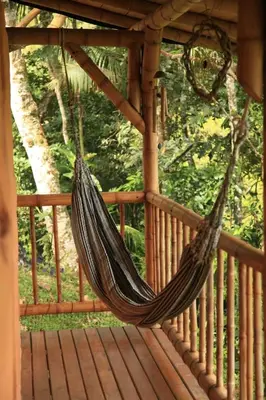 a hammock hanging on a wooden deck at Aracari Ecolodge in San Rafael