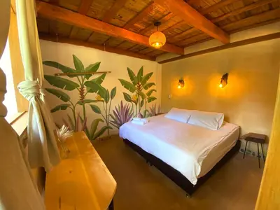 a bedroom with a bed with a plant mural on the wall at Aracari Ecolodge in San Rafael