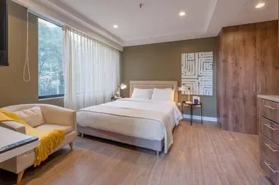 a bedroom with a large bed and a couch at El Tesoro Medellín Hab309 by Letoh in Medellín