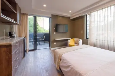 a hotel room with a bed and a kitchen and a bathroom at El Tesoro Medellín Hab309 by Letoh in Medellín