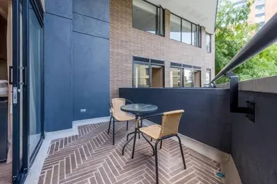 a patio with two chairs and a table in front of a building at El Tesoro Medellín Hab309 by Letoh in Medellín