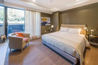 a bedroom with a bed and a chair and a window at El Tesoro Medellín Hab310 by Letoh in Medellín
