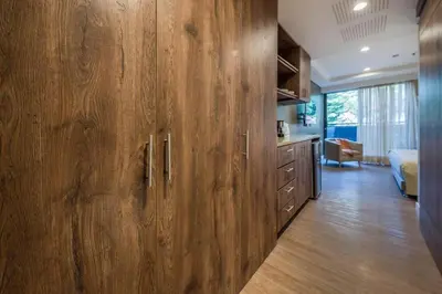 a kitchen with a large wooden cabinet in a room at El Tesoro Medellín Hab310 by Letoh in Medellín