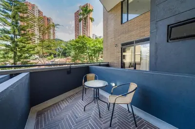 a small table and two chairs on a balcony at El Tesoro Medellín Hab310 by Letoh in Medellín