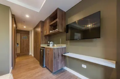 a kitchen with wooden cabinets and a counter top at El Tesoro Medellín Hab311 by Letoh in Medellín
