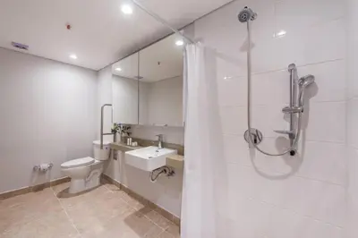 a white bathroom with a shower and a toilet at El Tesoro Medellín Hab311 by Letoh in Medellín